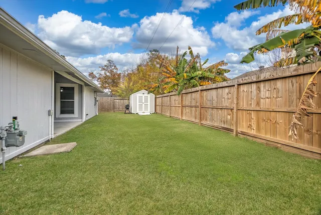 a view of a yard with wooden fence