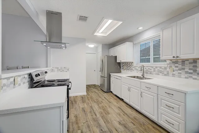 a kitchen with a stove a sink and a refrigerator