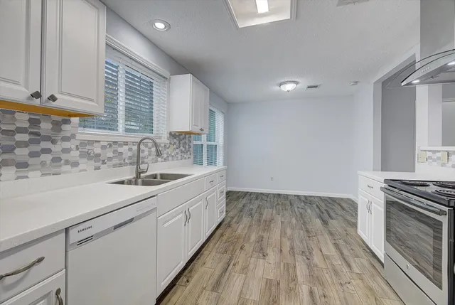 a kitchen with a sink wooden floor and a stove