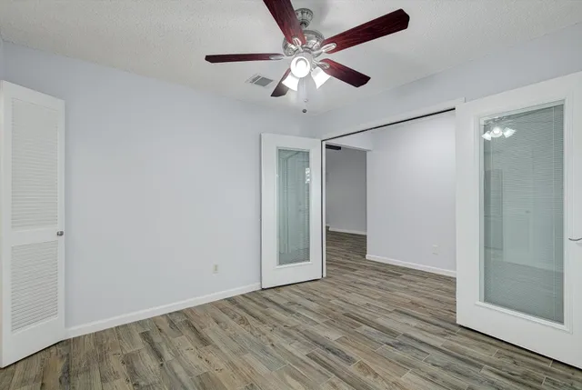 a view of an empty room with wooden floor