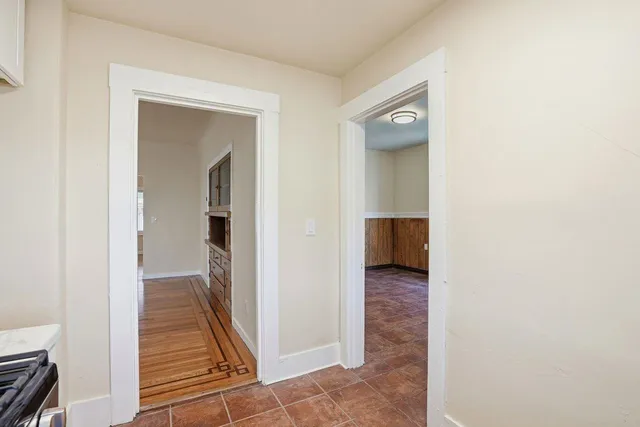 a view of a hallway with wooden floor and closet