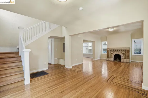 a view of a livingroom with wooden floor and a fireplace