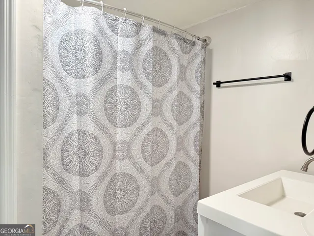 a bathroom with a sink and shower curtain