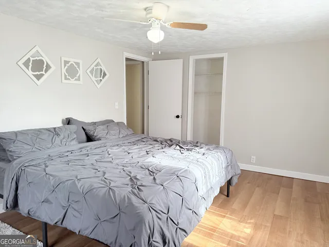 a bed sitting in a bedroom next to a window and a chandelier