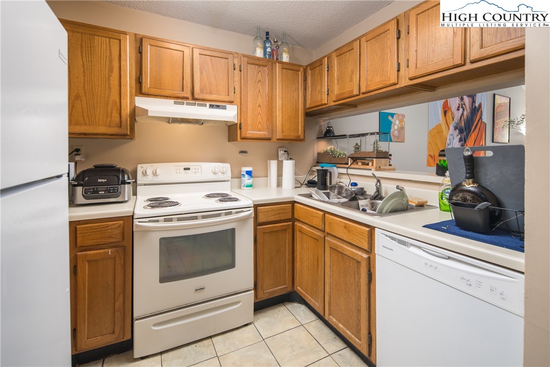 236 Oak Street, Unit H12 Boone, NC 28607 - Photo 5 of 22 a kitchen with stainless steel appliances granite countertop a sink and cabinets