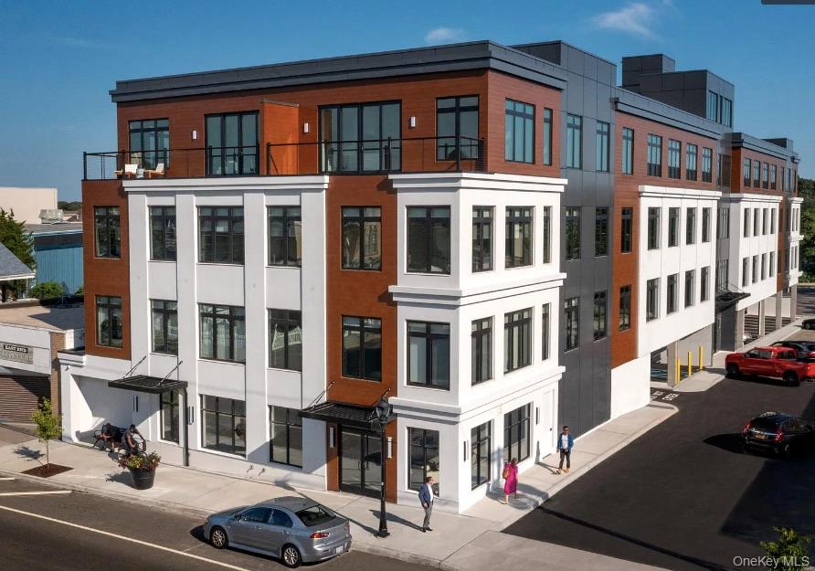 331 East Main Street, Unit 405 Riverhead, NY 11901 - Photo 1 of 1 a front view of a building with parking space
