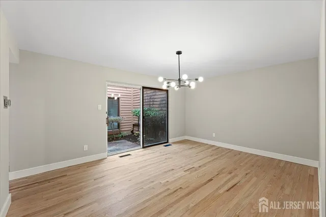 a view of a room with wooden floor and ceiling fan