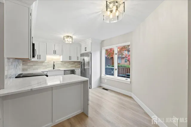 a kitchen with cabinets appliances a sink and a counter top space