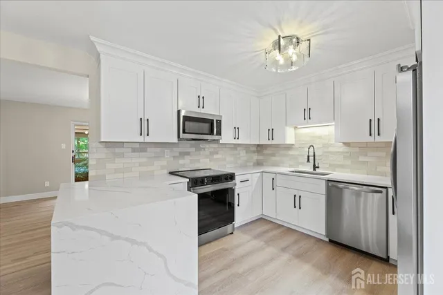 a kitchen with cabinets stainless steel appliances and a sink