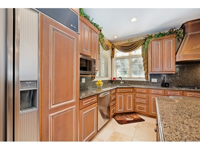 1415 Tyrell Avenue Park Ridge, IL 60068 - Photo 11 of 25 a kitchen with stainless steel appliances granite countertop a refrigerator a sink dishwasher and wooden cabinets with a large window