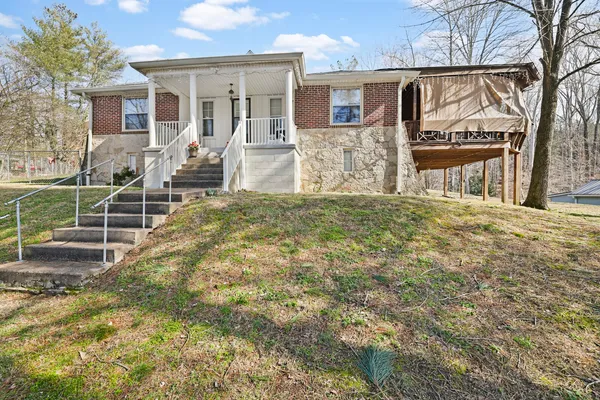 a view of a house with backyard and a tree