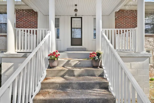 a view of a hallway with wooden floor and stairs