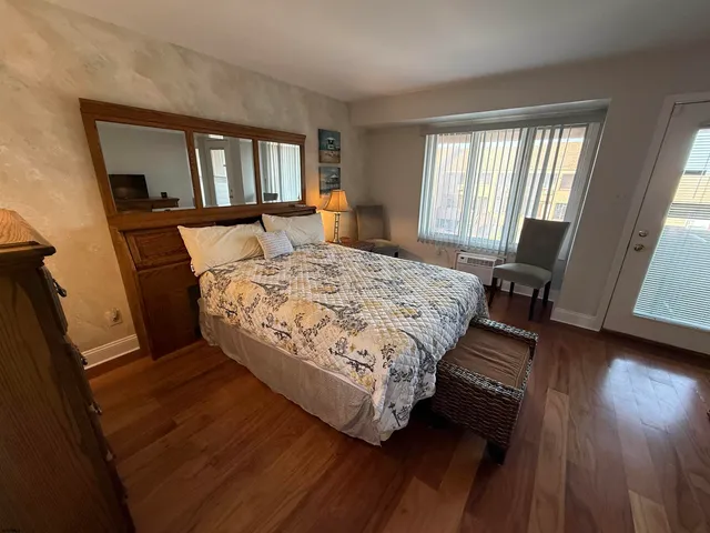 a bedroom with a bed wooden floor and window
