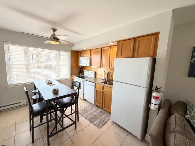 a kitchen with a refrigerator a stove a dining table and chairs