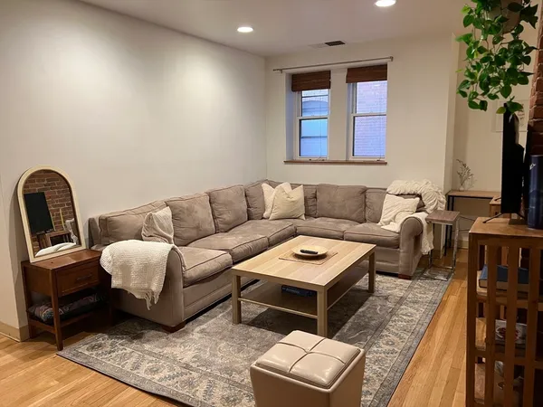 a living room with furniture a flat screen tv and a large window