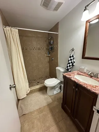 a bathroom with a granite countertop sink toilet and shower