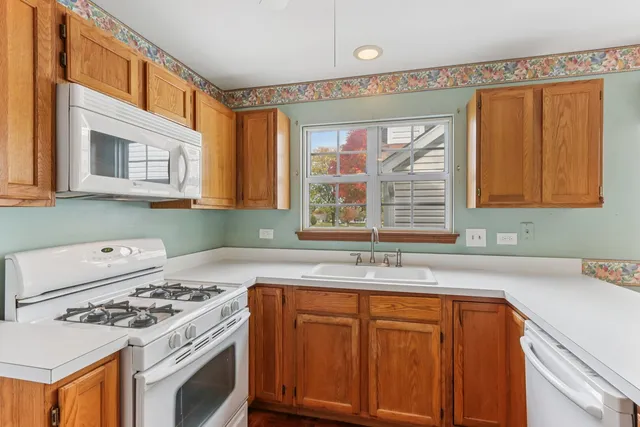 a kitchen with granite countertop a sink stove and refrigerator