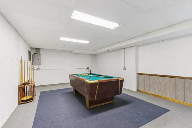 a living room with couch cabinet and a refrigerator