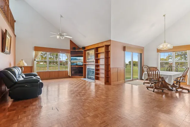 a living room with furniture floor to ceiling window and wooden floor