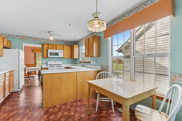 a kitchen with a table chairs sink and cabinets