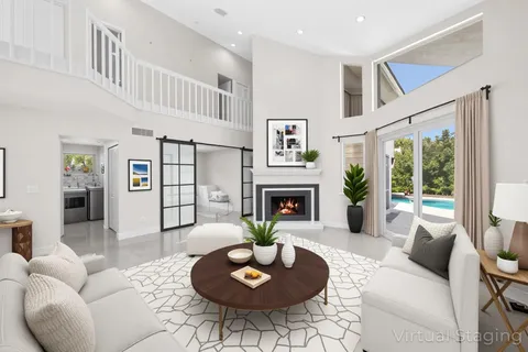 a living room with furniture a fireplace and a large window