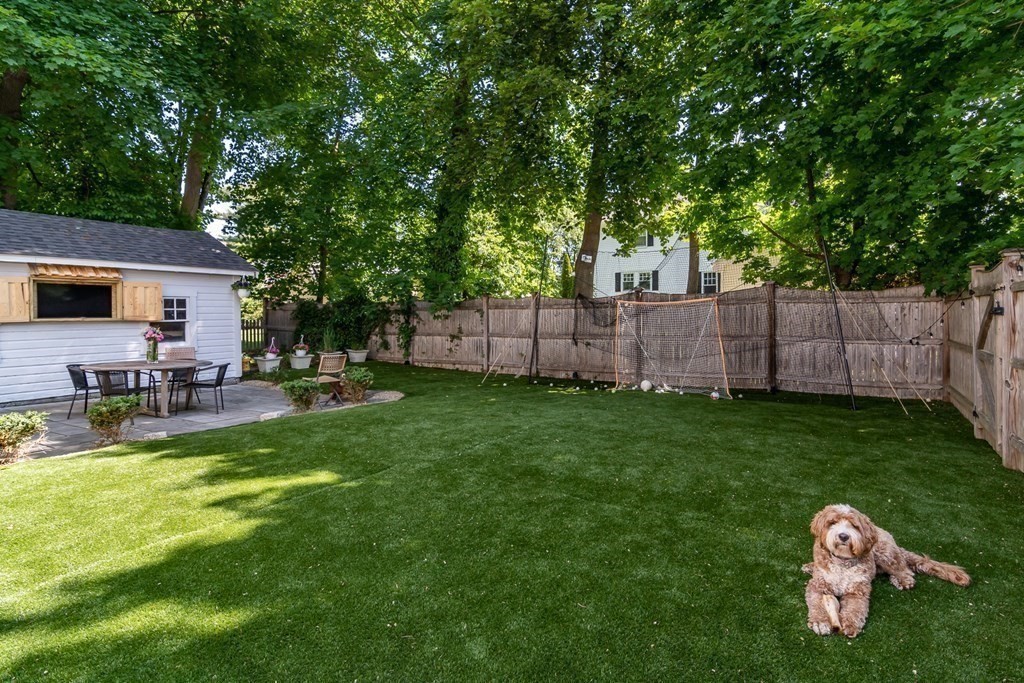 3 Claflin Road Wellesley, MA 02482 - Photo 19 of 20 a view of a backyard with table and chairs and wooden fence