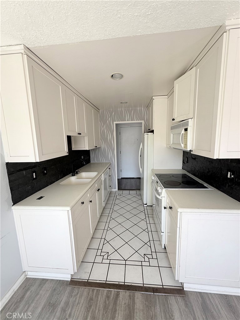 12200 Montecito Road, Unit D221 Seal Beach, CA 90740 - Photo 8 of 25 Galley kitchen with tile floors and stone backsplash