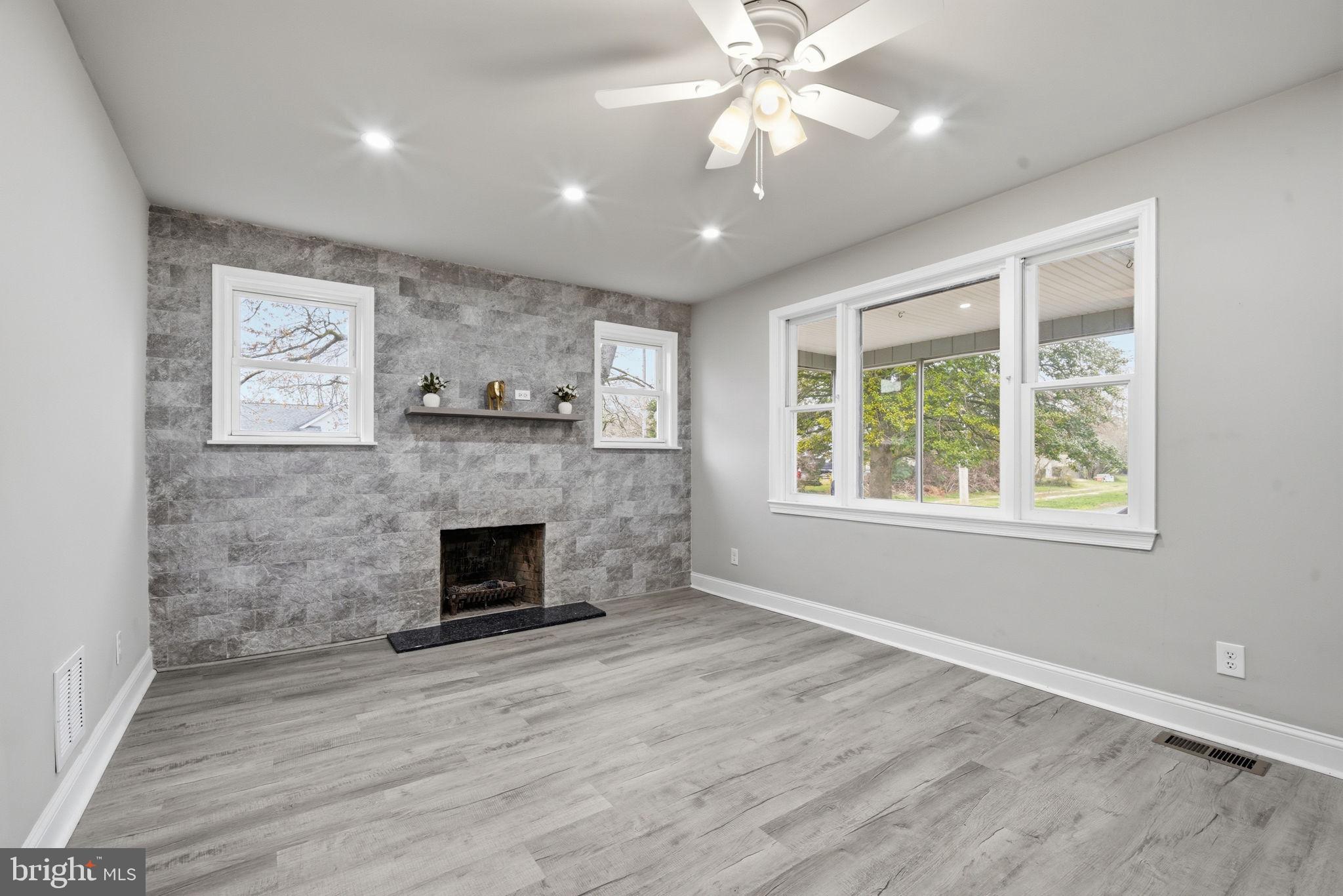 21305 Haven Road Rock Hall, MD 21661 - Photo 6 of 52 an empty room with windows fireplace and fan