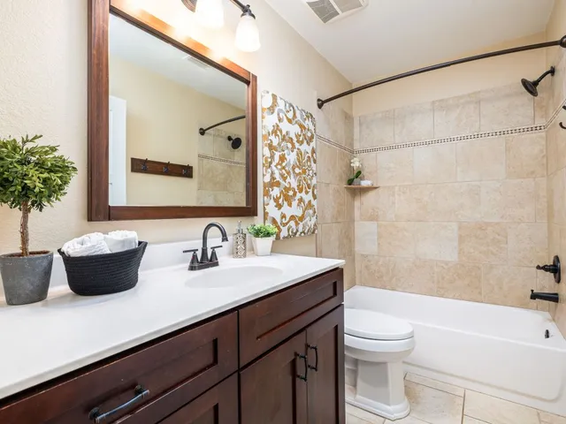 a bathroom with a sink a toilet a mirror and shower