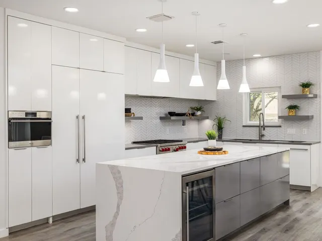 a kitchen with stainless steel appliances a stove a sink a refrigerator and cabinets