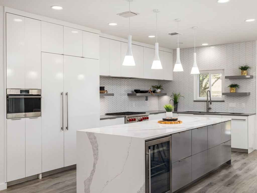 8004 Osborne Drive Austin, TX 78729 - Photo 4 of 24 a kitchen with stainless steel appliances a stove a sink a refrigerator and cabinets