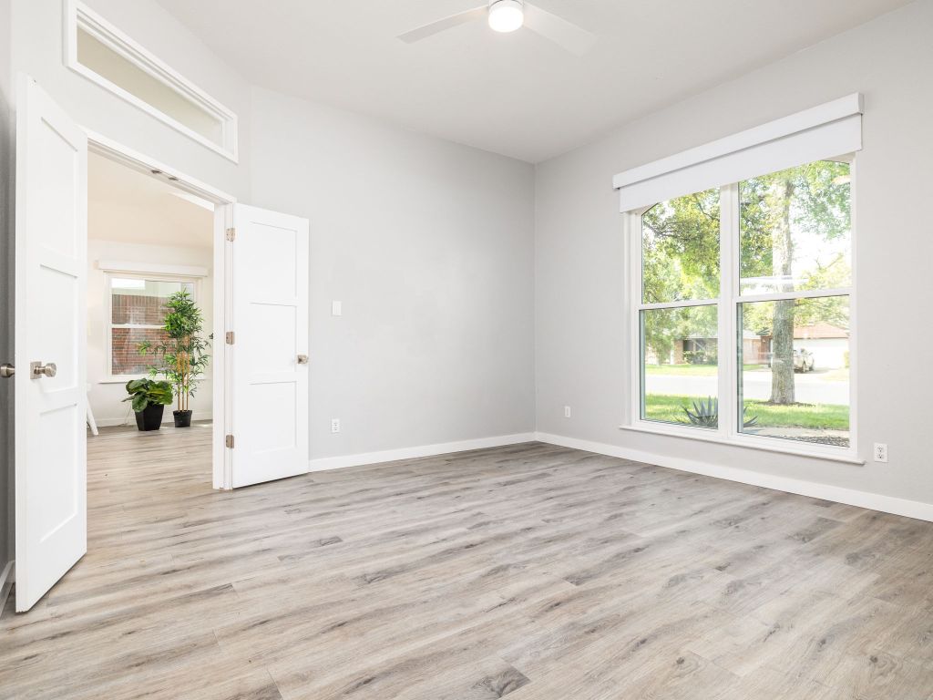 8004 Osborne Drive Austin, TX 78729 - Photo 9 of 24 a view of an empty room with wooden floor and a window