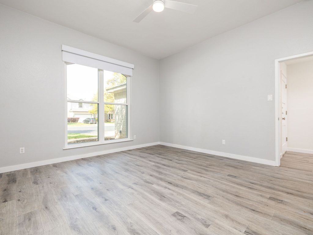 8004 Osborne Drive Austin, TX 78729 - Photo 10 of 24 an empty room with wooden floor and windows