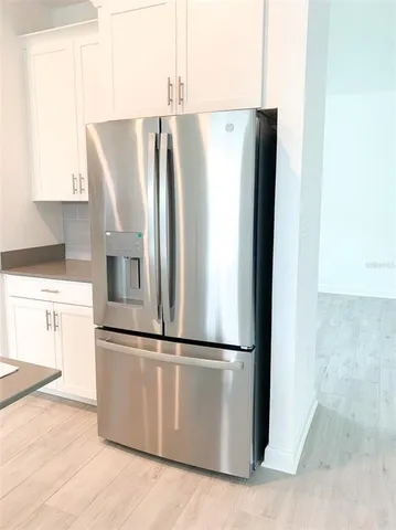 a view of an empty room with wooden floor and stairs