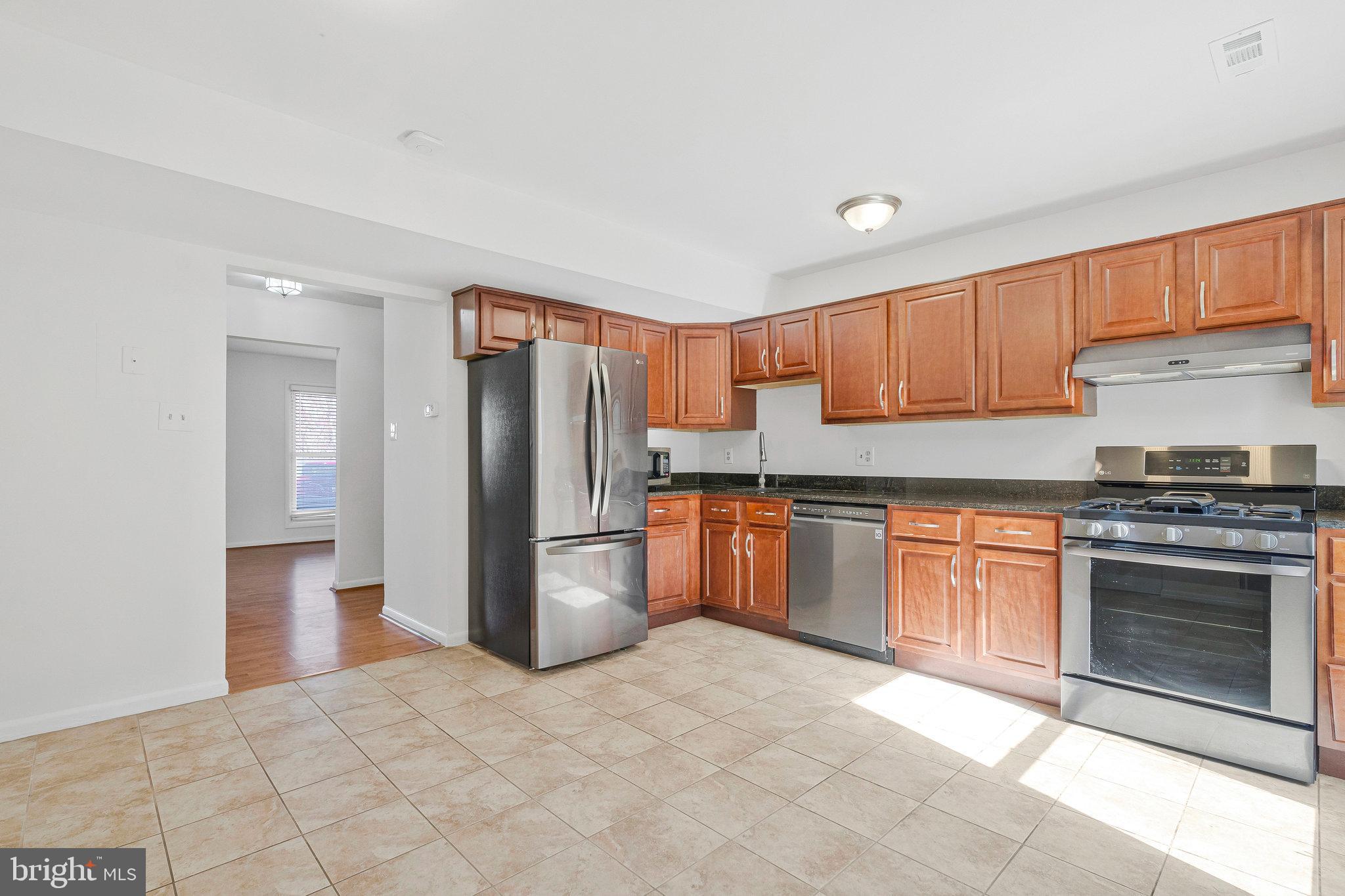 2131 Ferguson Place Herndon, VA 20170 - Photo 5 of 27 a kitchen with stainless steel appliances granite countertop a refrigerator sink and stove