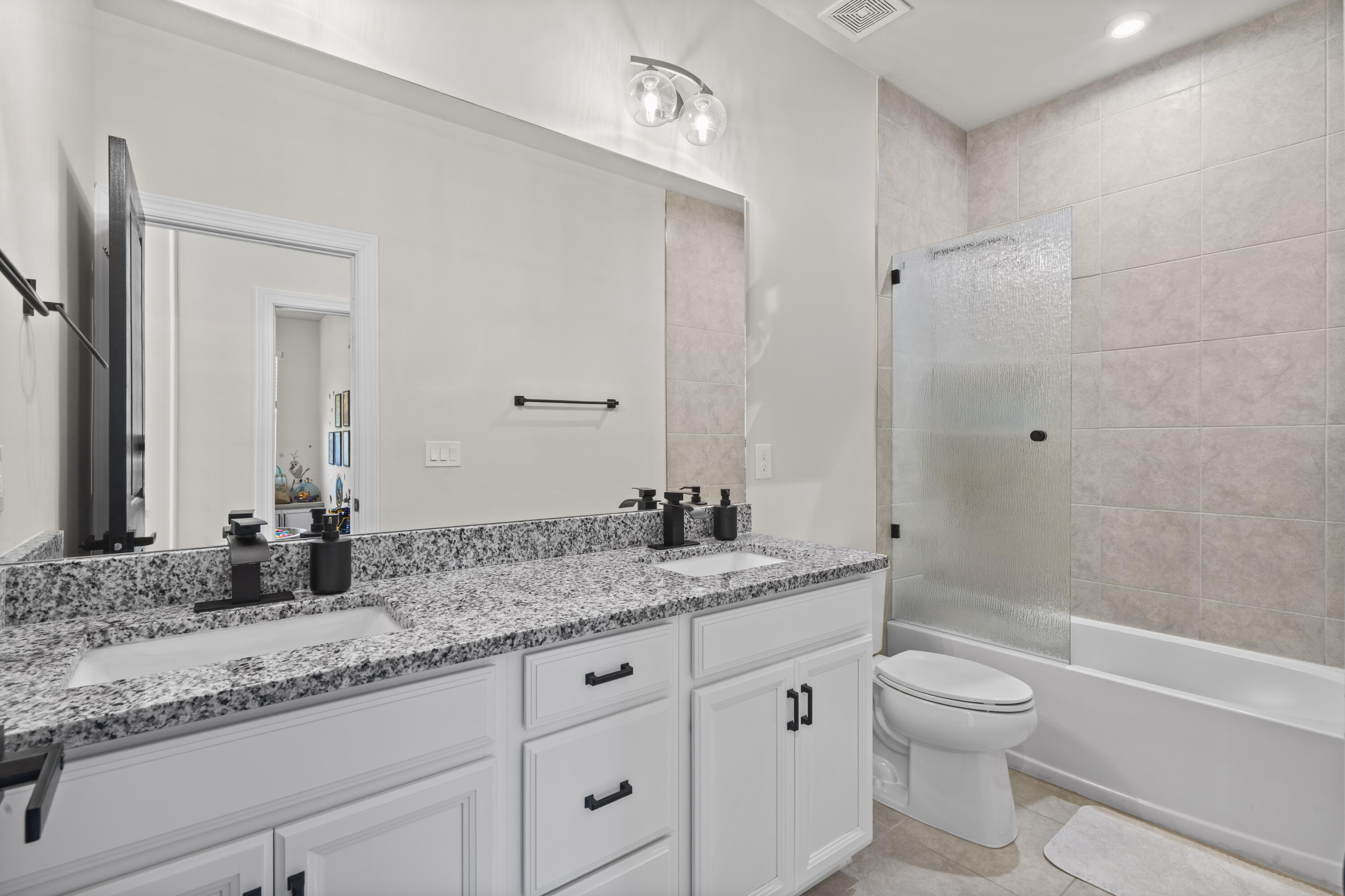 684 Southwest Pennfield Terrace Stuart, FL 34997 - Photo 31 of 61 a bathroom with a granite countertop sink a toilet and shower