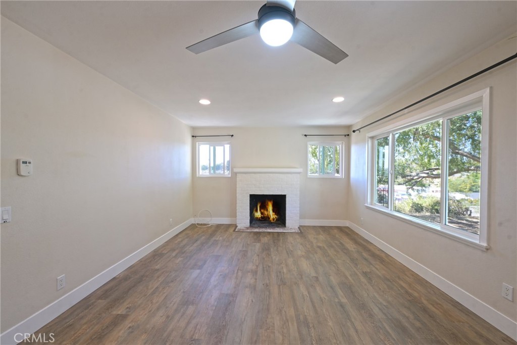 127 East College Street Fallbrook, CA 92028 - Photo 12 of 58 an empty room with windows a fireplace and wooden floor