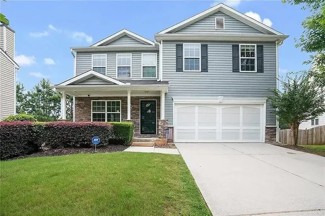 a front view of a house with a yard and outdoor seating