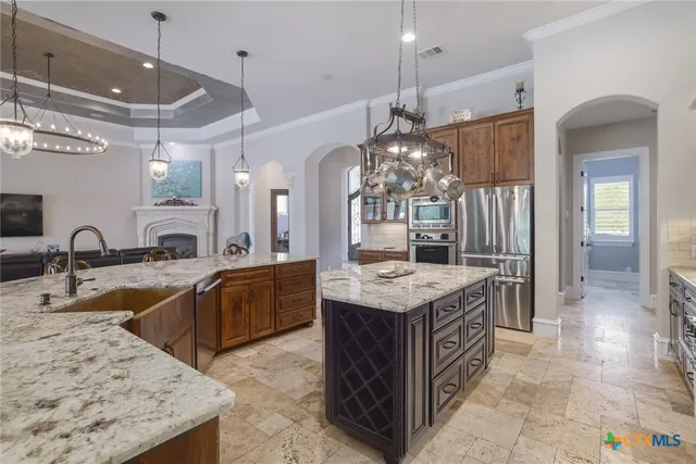 a large kitchen with kitchen island a sink a counter top space and stainless steel appliances