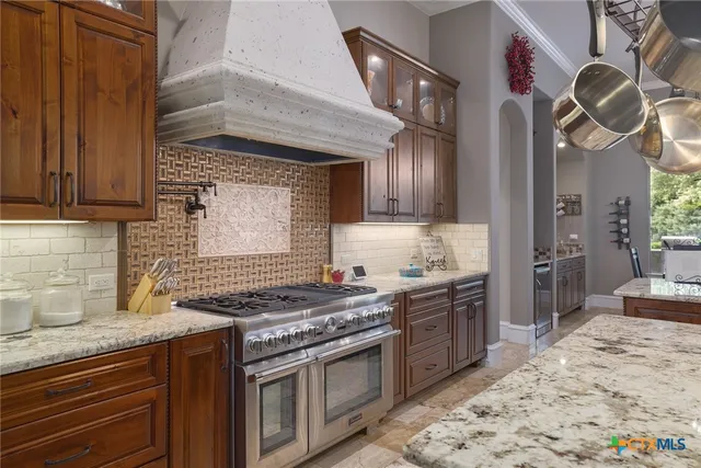 a kitchen with stainless steel appliances granite countertop a stove sink and cabinets