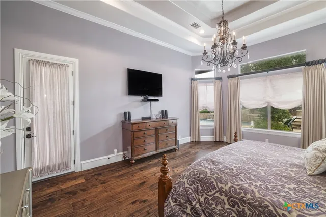 a spacious bedroom with a bed and a flat screen tv