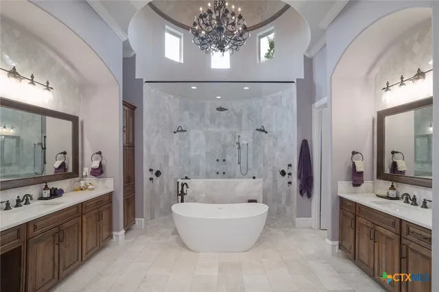 a spacious bathroom with a double vanity sink a large mirror a bathtub and shower