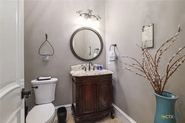 a bathroom with a toilet a sink and a mirror