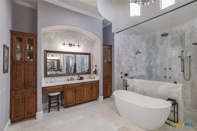 a bathroom with a tub a sink and a mirror