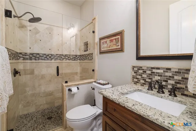 a bathroom with a granite countertop toilet sink and shower
