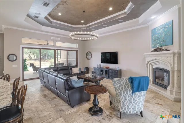 a living room with furniture a fireplace and a chandelier