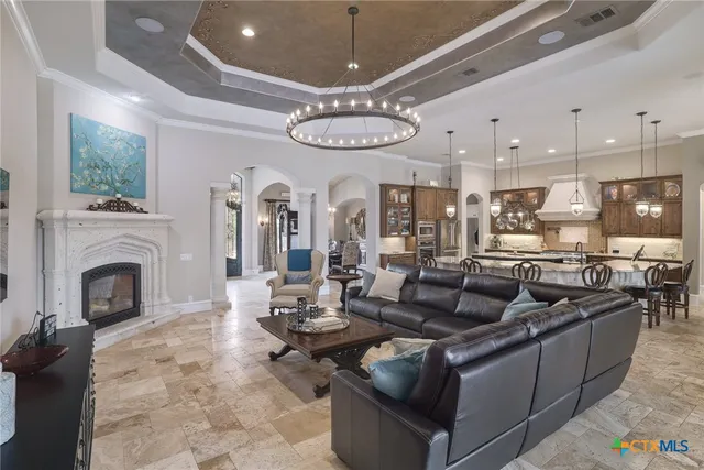 a living room with fireplace furniture and a chandelier