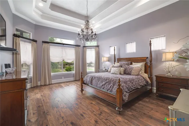 a spacious bedroom with a large bed and a chandelier