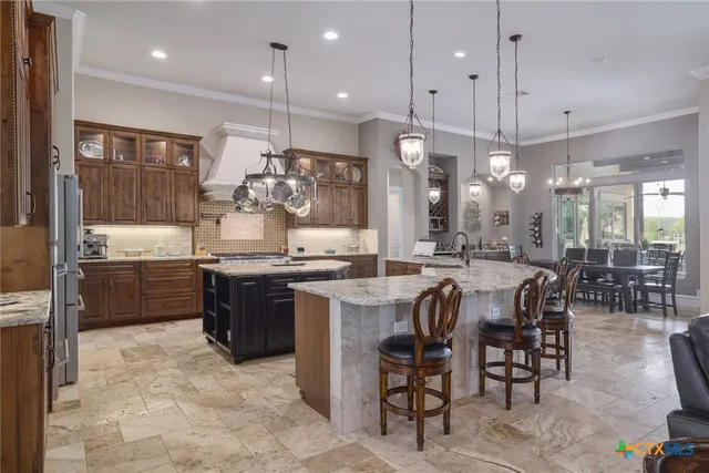 a kitchen with a refrigerator a sink dishwasher a dining table and chairs