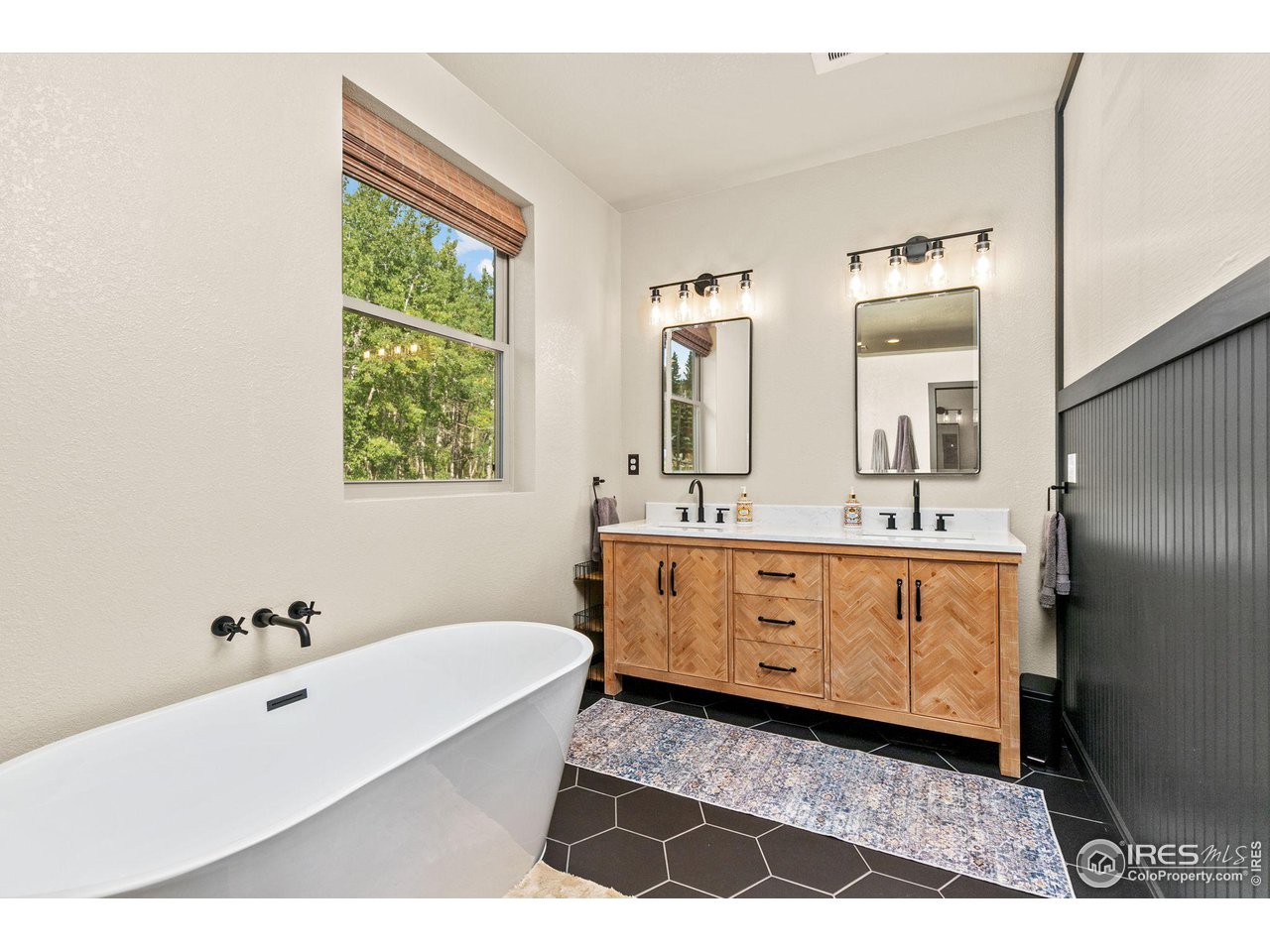 2833 Lump Gulch Road Black Hawk, CO 80422 - Photo 17 of 40 a bathroom with a double vanity sink a mirror and a bathtub